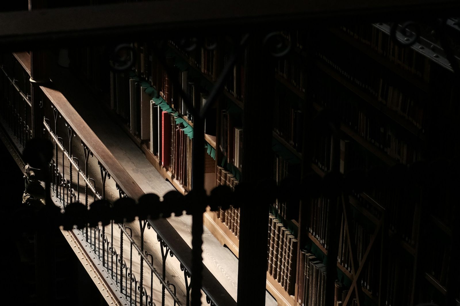 Bibliothèque en pénombre traversée par des rayons de lumière dorée sur des rayonnages anciens, métaphore du GEO Generative Engine Optimization : devenir une source de référence citée par ChatGPT, Perplexity et Google AI Overviews