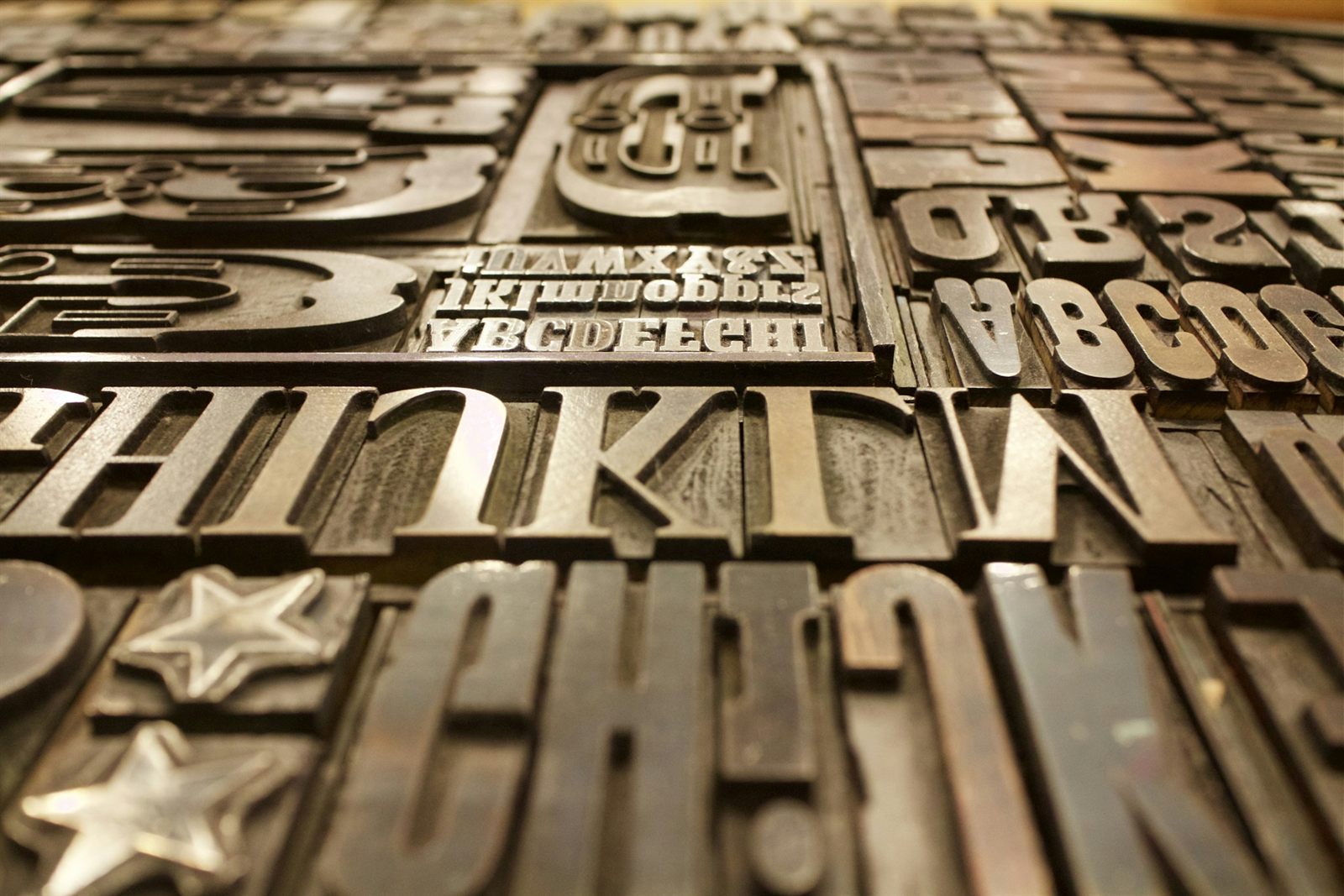 Typographie serif imprimée en gros plan macro avec textures de papier, métaphore d'un ton de voix de marque qui se reconnaît immédiatement et reste cohérent d'une publication à l'autre